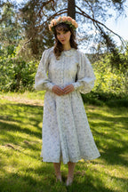 Maria wearing the Lily Dress standing in a sunlit forest
